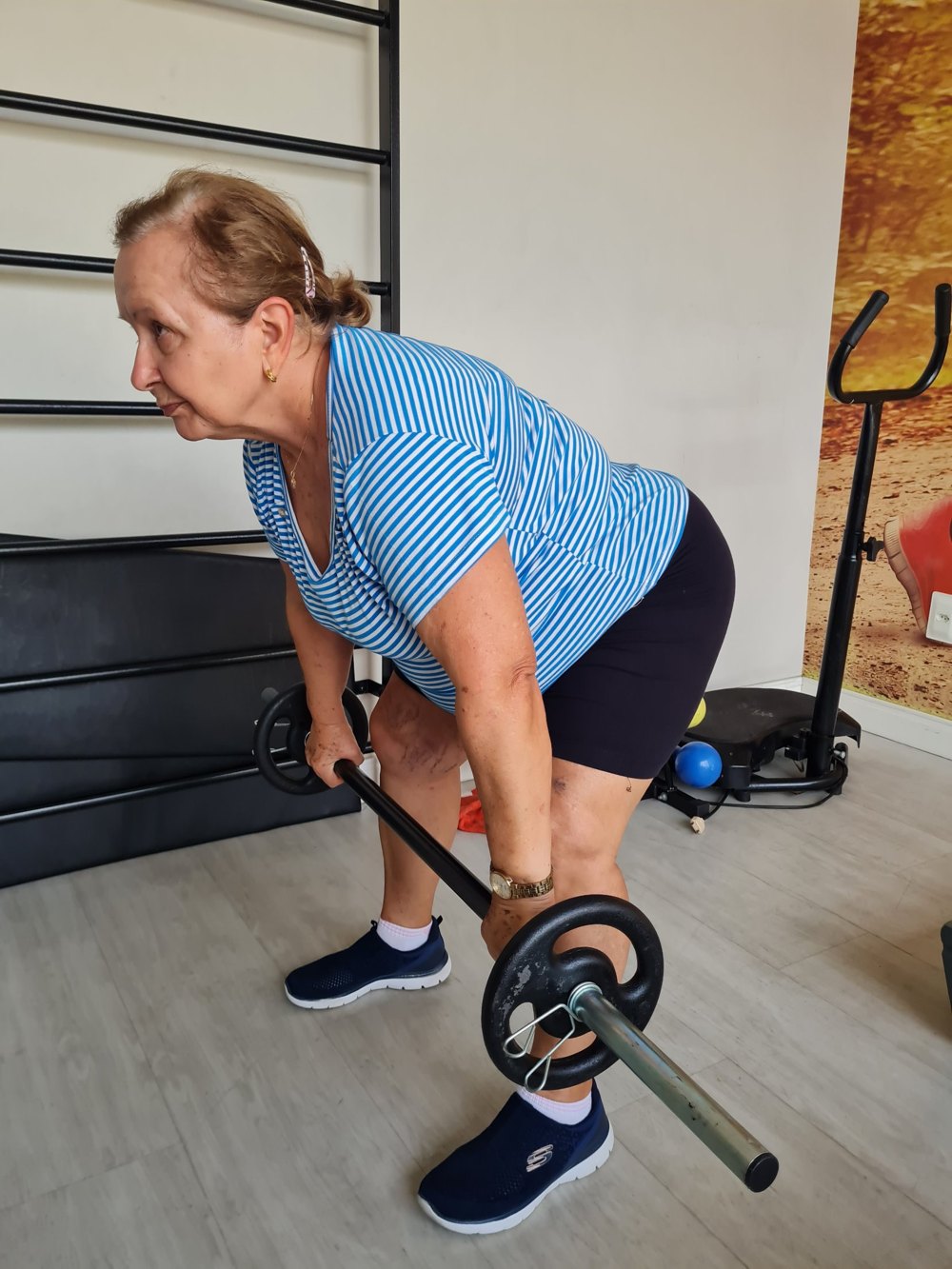 Aluna fazendo levantamento terra com barra